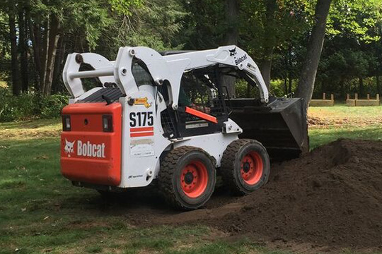 BML skid steer performing site grading on a residential property